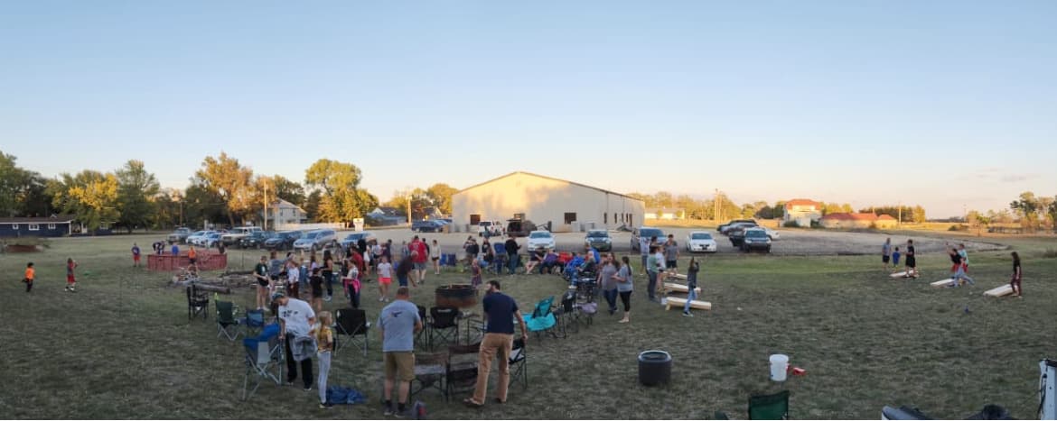 Families gathered around a fire pit at a church community event